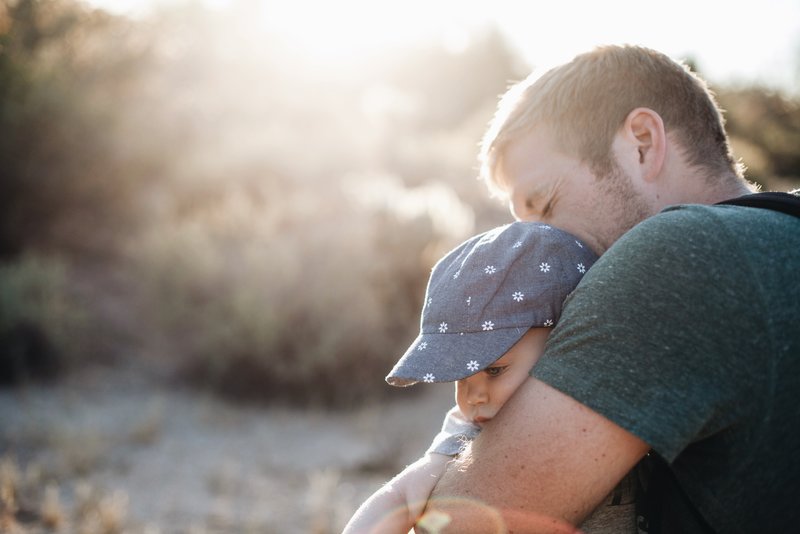 man hugging baby contemplating whether to open a child trust fund