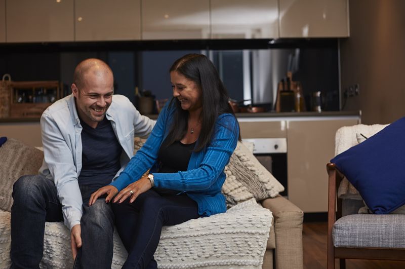 Couple laughing on sofa