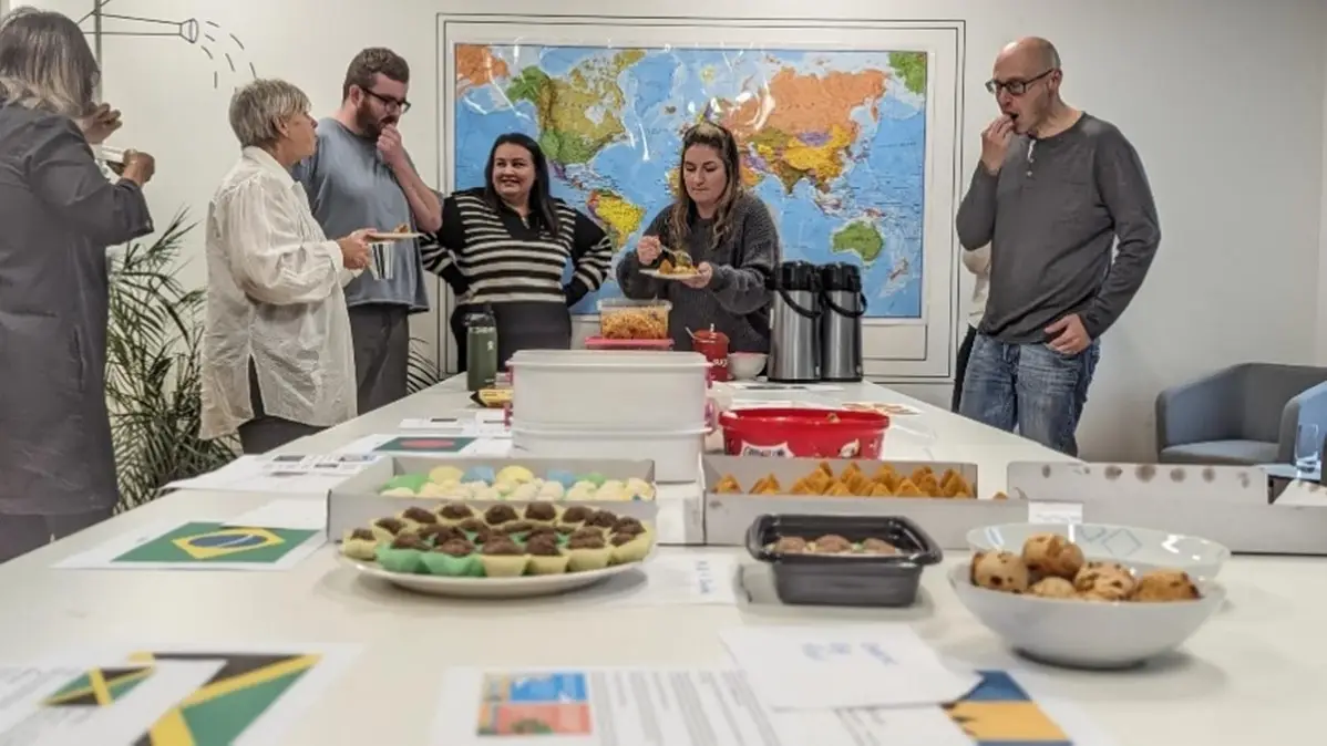 some of the shepherds friendly team members stood around a table of food during a together day