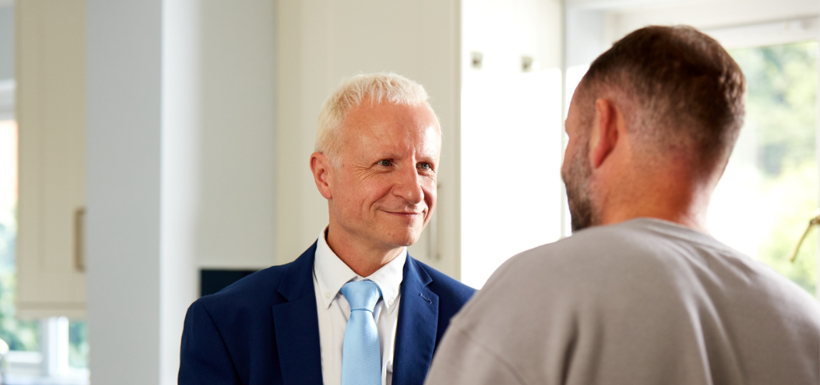 Two men smiling at one another
