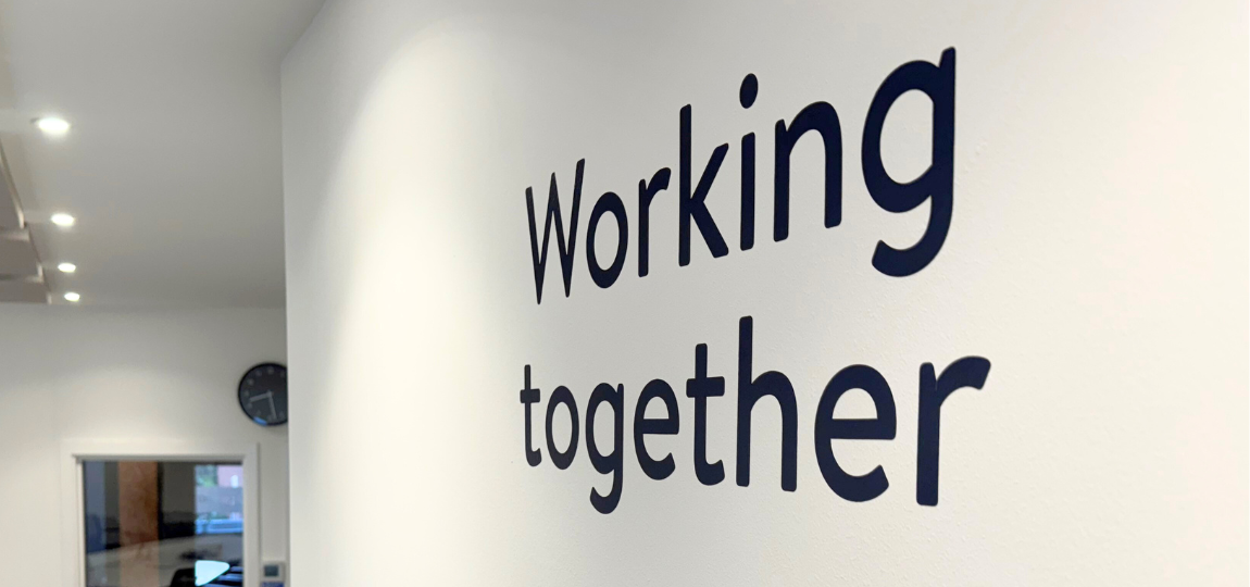 Writing on office wall that says 'working together'